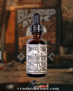 Crooked Crows amber dropper bottle on a dark table